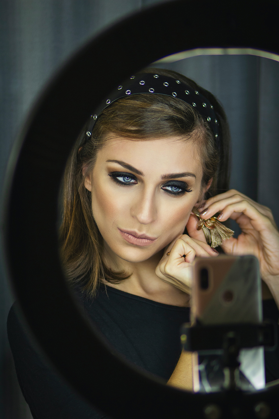 A woman is putting on makeup in a mirror.