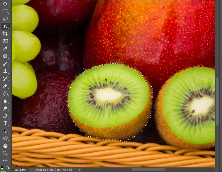 A photo of kiwis and grapes in a basket.