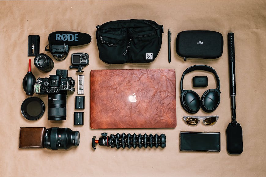 A laptop, camera, and other items laid out on a table.