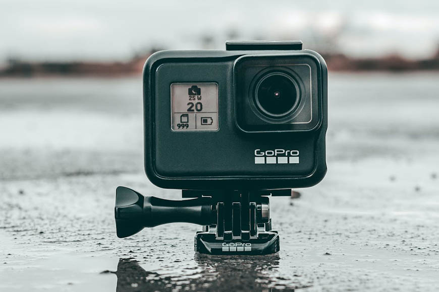 A gopro hero sits on a puddle of water.