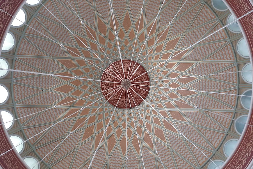 The ceiling of a building with a circular design.