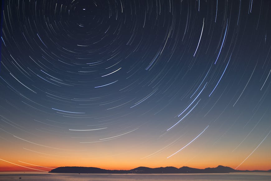 Star trails over the ocean at sunset.