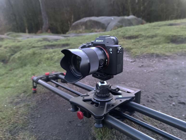 A camera sits on a slider in a field.