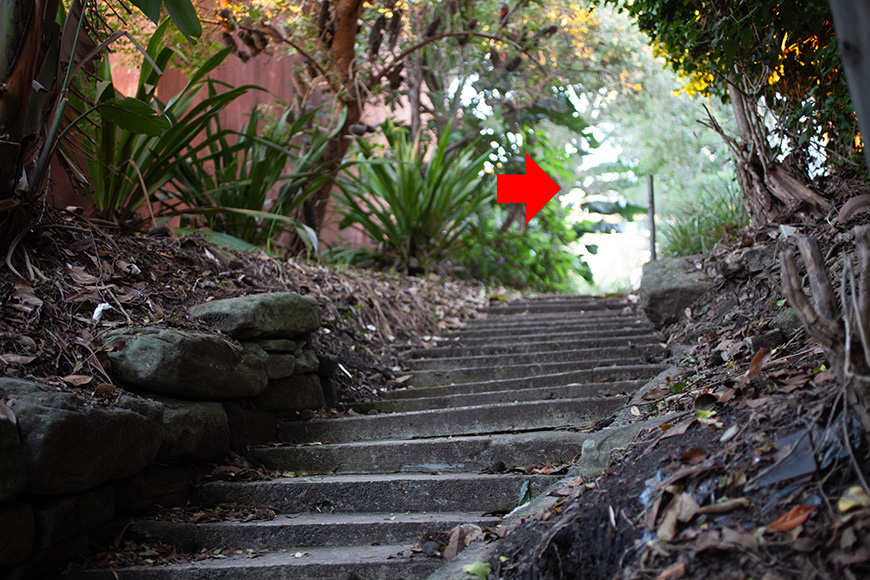 A red arrow pointing down a set of stairs.