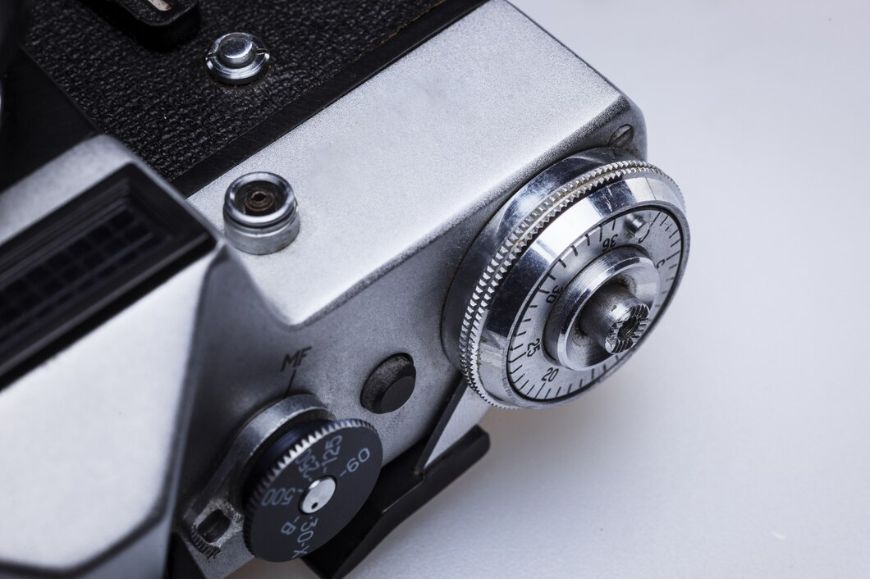 A close up of a silver camera with a knob.
