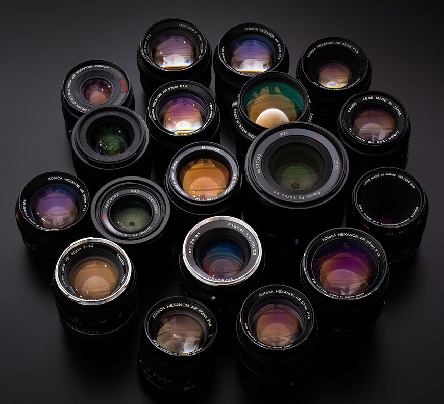 A group of camera lenses arranged on a black surface.