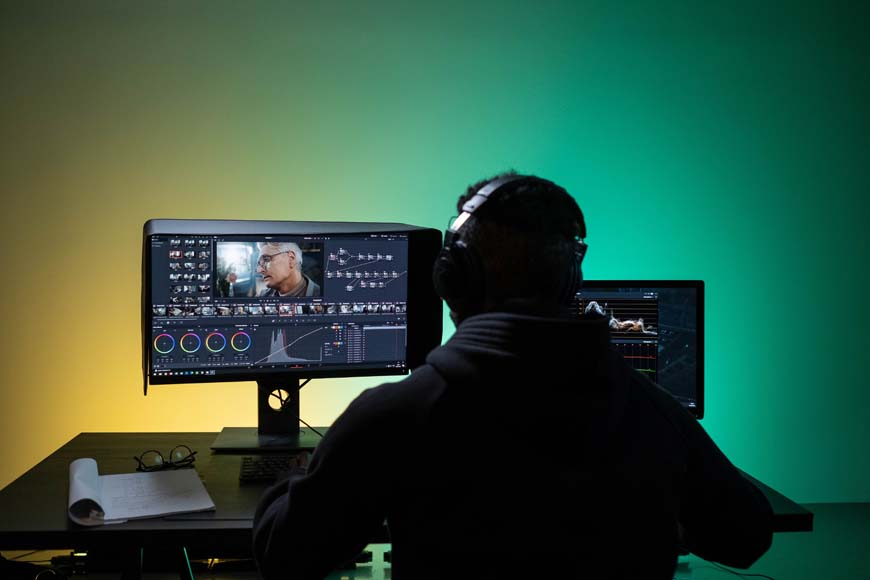 A man sitting at a desk with two monitors.