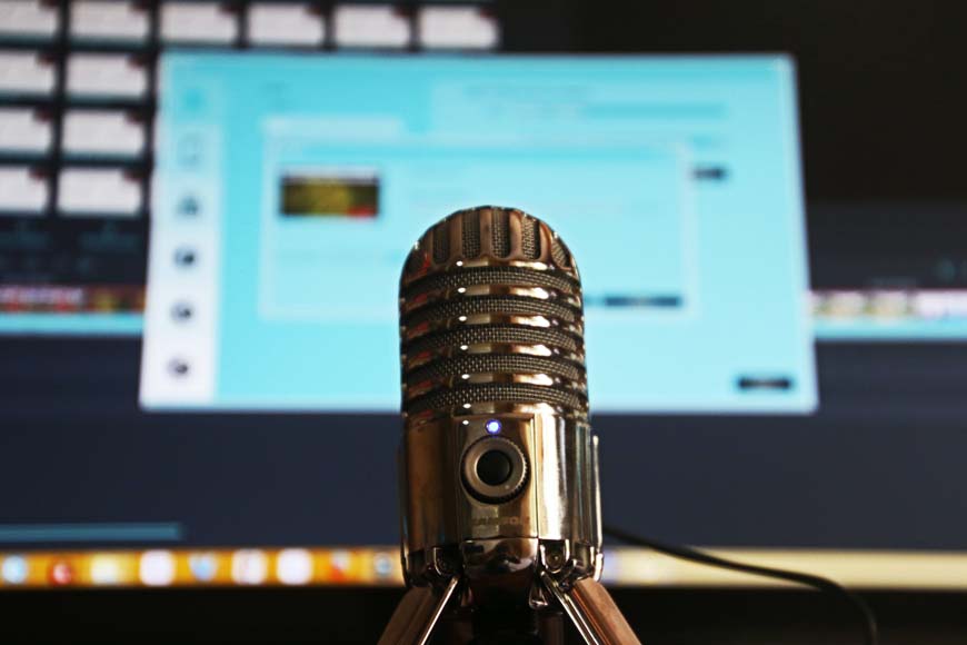 A microphone in front of a computer screen.