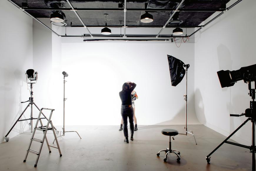 A woman is standing in front of a camera in a studio.