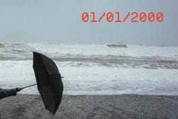 A person holding an umbrella on a beach.