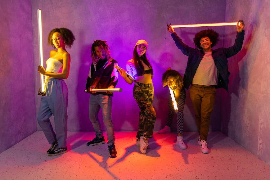 A group of people holding flashlights in a purple room.