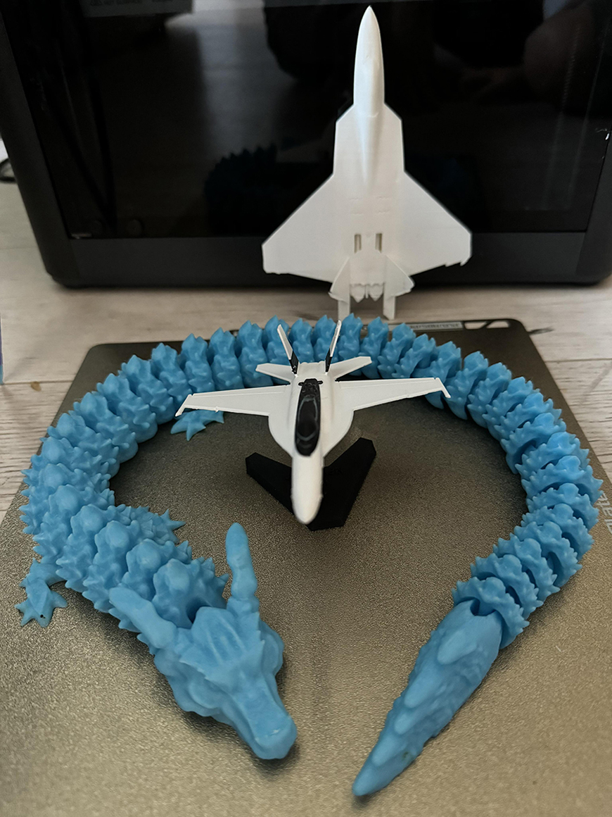 A 3d printed model of a dragon and a jet plane.