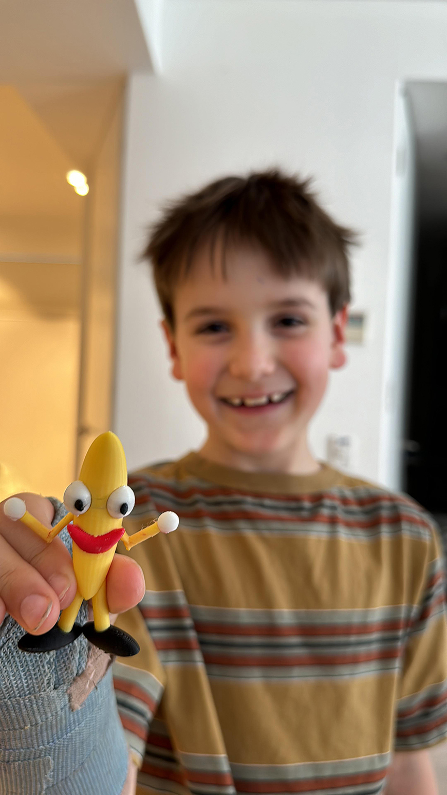 A boy holding a toy banana.