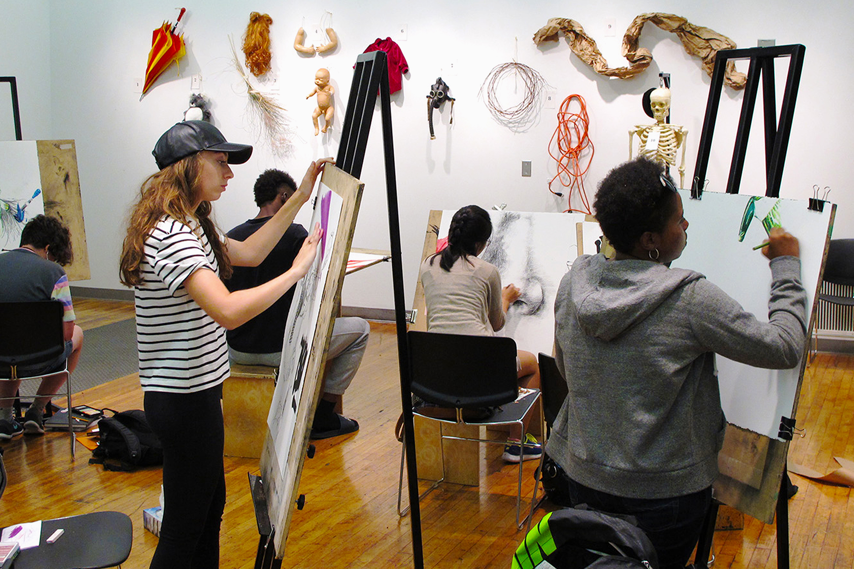 A group of people working on easels in an art studio.