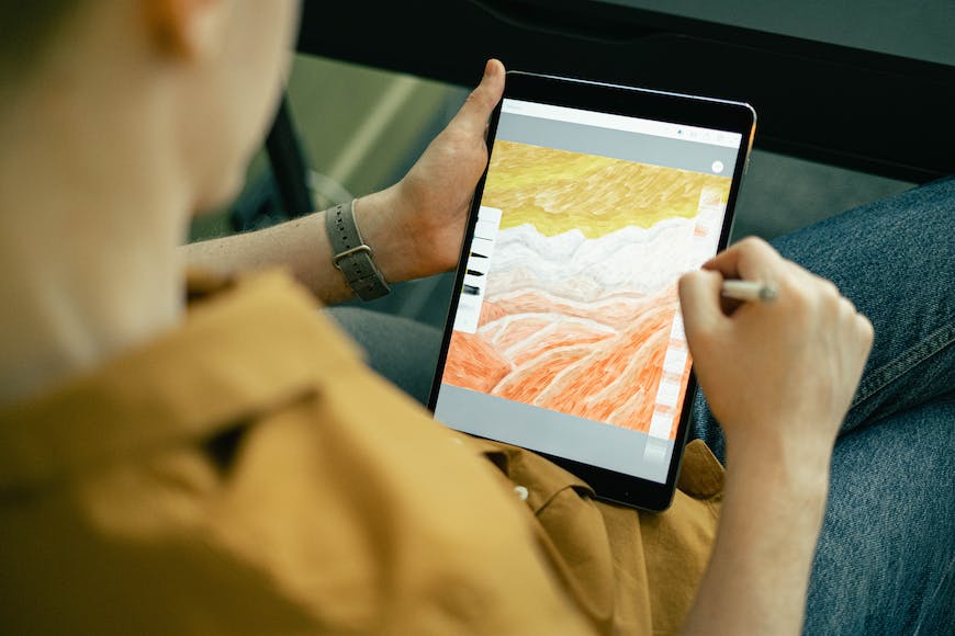 A woman is using a tablet to draw a picture.