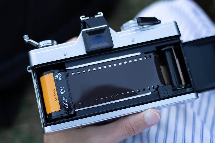 A person holding a camera with film in it.