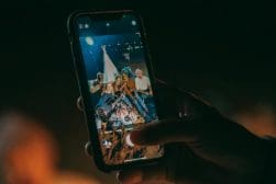 A person taking a picture of a group of people at a concert.