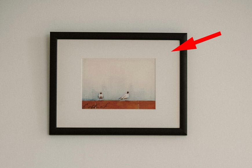 A framed painting with an arrow pointing to it.
