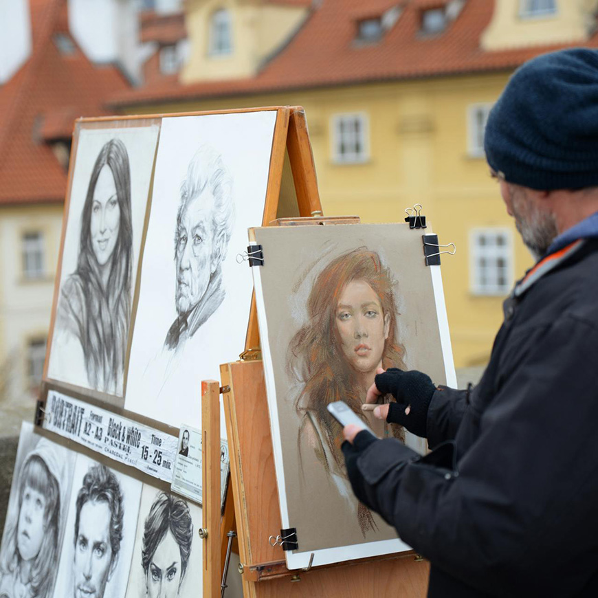 A man is painting a portrait on an easel.