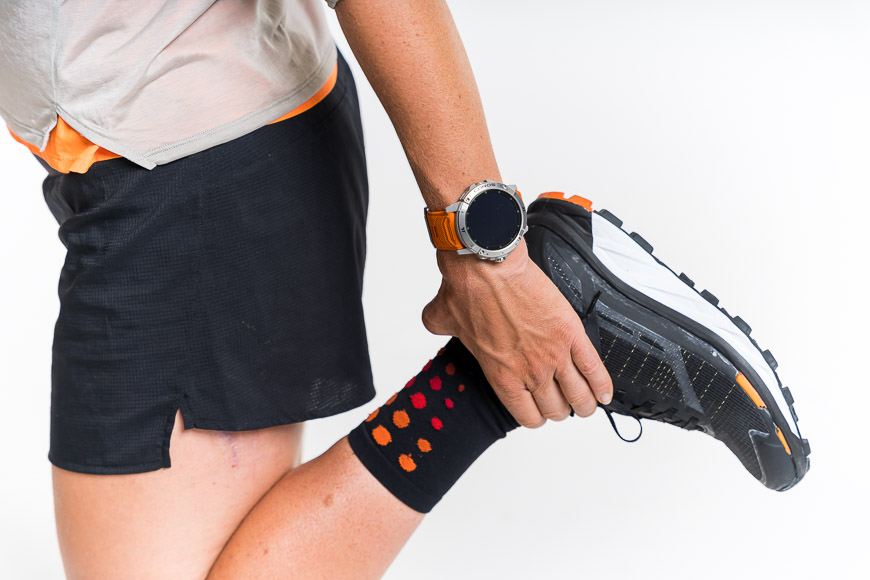 A woman wearing a pair of running socks and a watch.