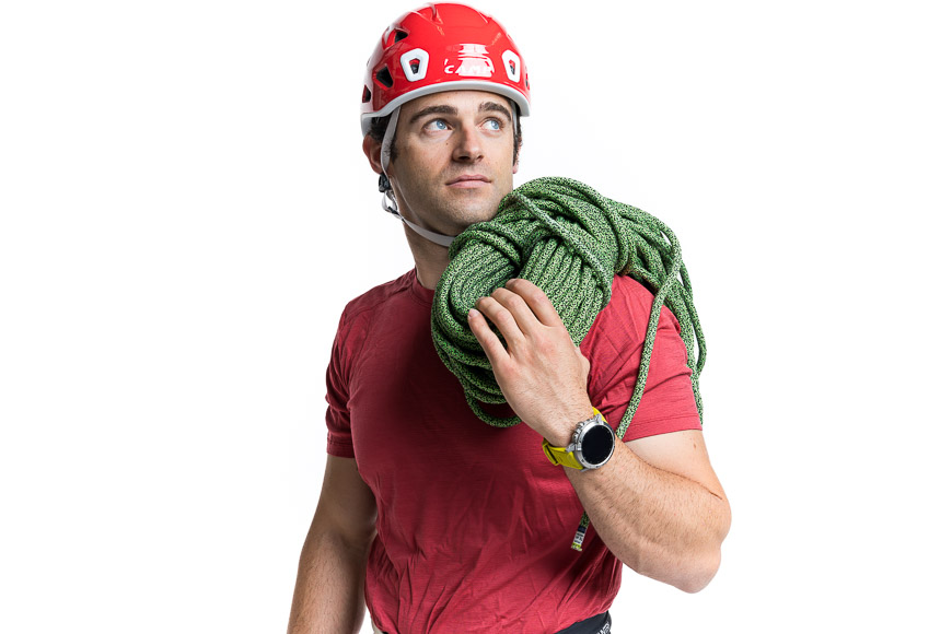 A man wearing a helmet and carrying a rope.