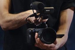 A person holding a camera and a microphone.
