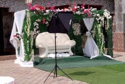 A wedding stage set up with flowers and a chair.