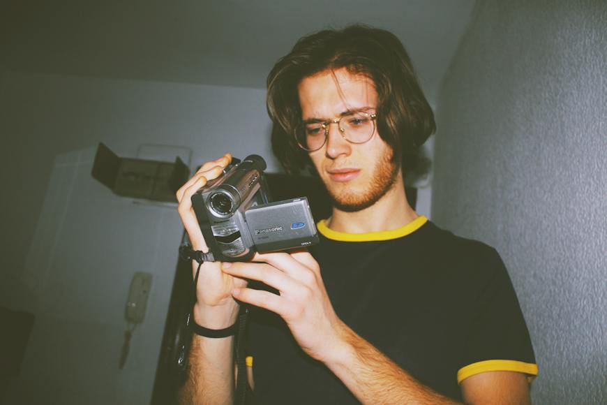 A young man holding a camera.
