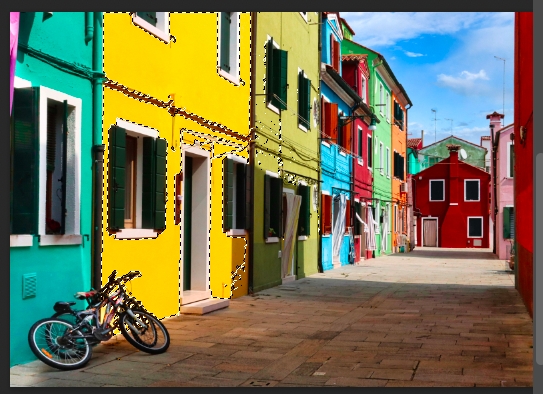 A bicycle is parked in front of a colorful building.