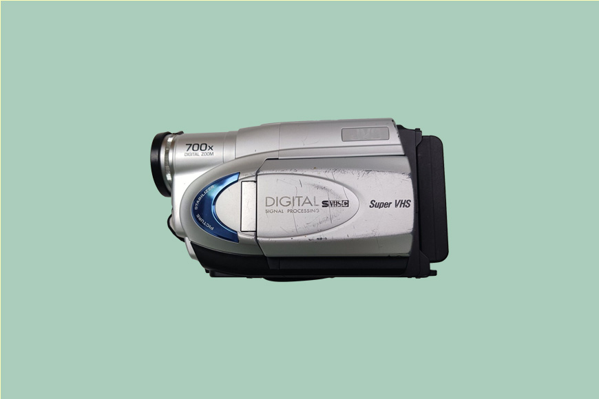 A silver camcorder on a green background.