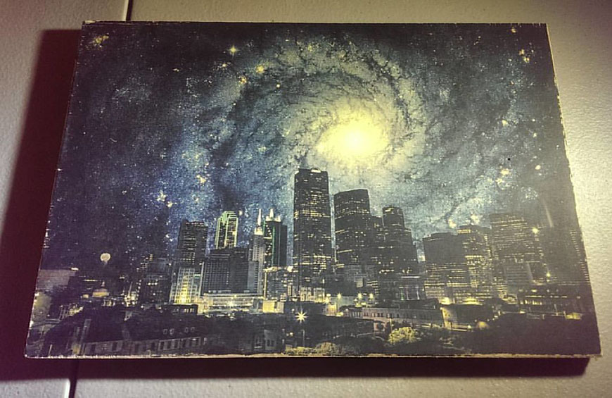 A picture of a city with a galaxy in the background.