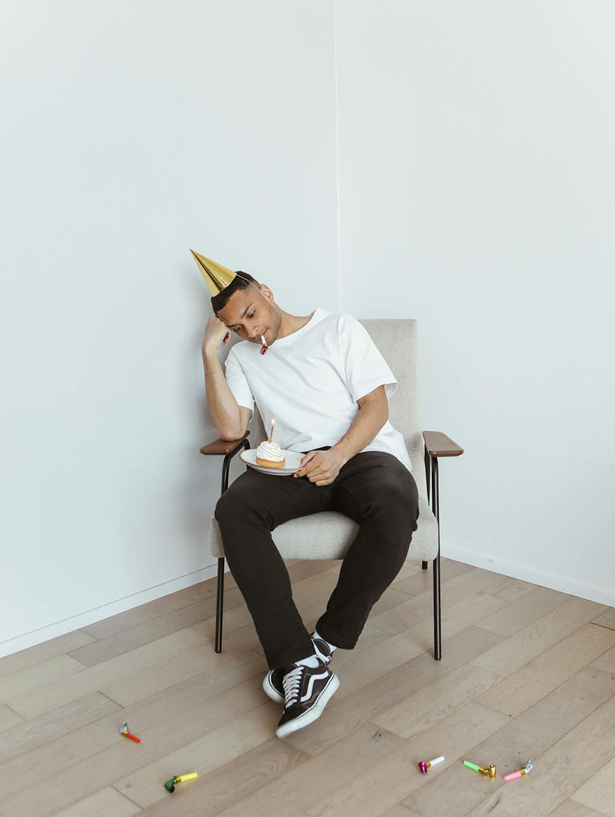 A man in a party hat sitting in a chair.