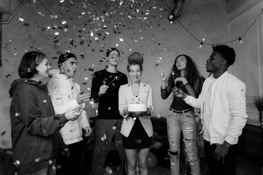 Black and white photo of a group of friends celebrating a birthday.
