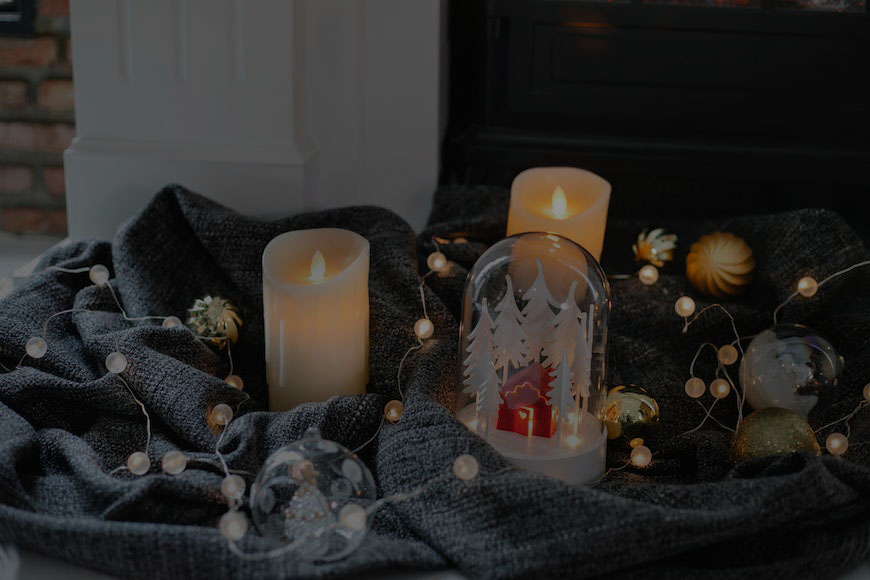 A fireplace with candles and ornaments in front of it.