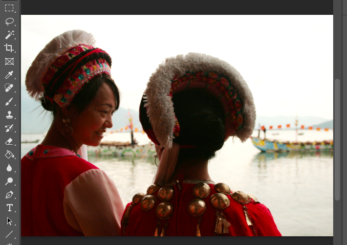 Two women in traditional chinese clothing standing next to a body of water.