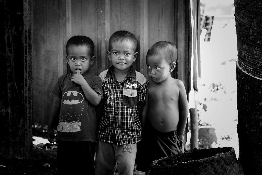 Three boys standing in front of a door.