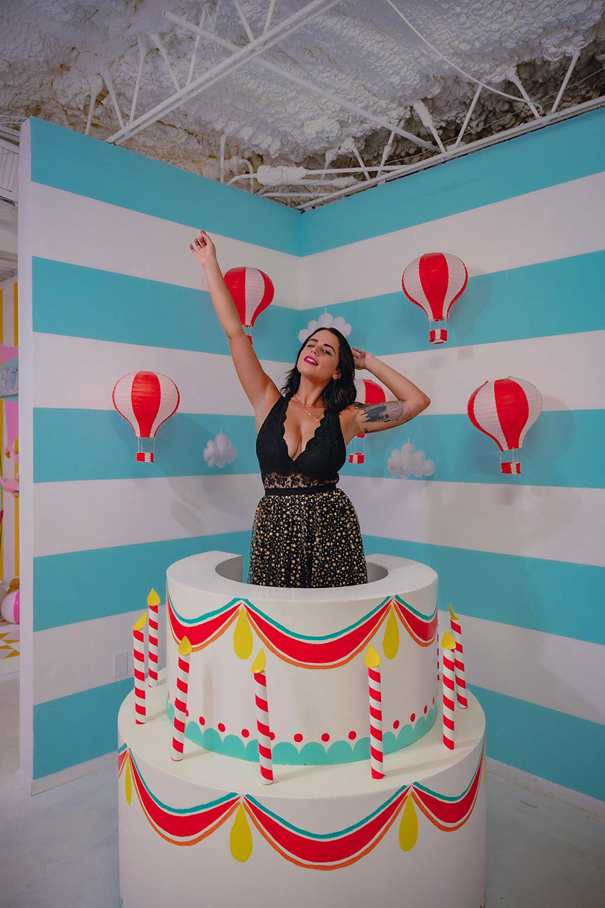 A woman standing in front of a birthday cake.