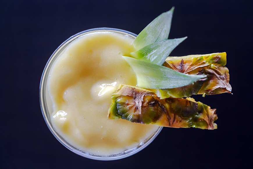 A drink with a slice of pineapple on top.