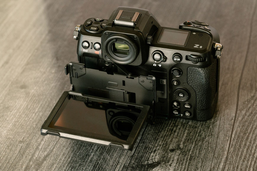 Professional digital camera with an articulated lcd screen on a wooden surface.