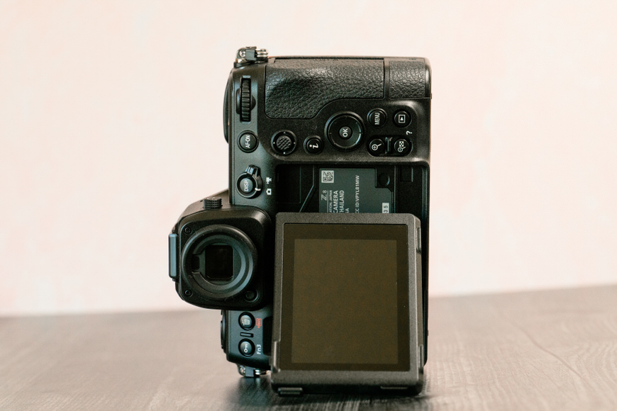 Digital slr camera with a flipped-out screen on a table.