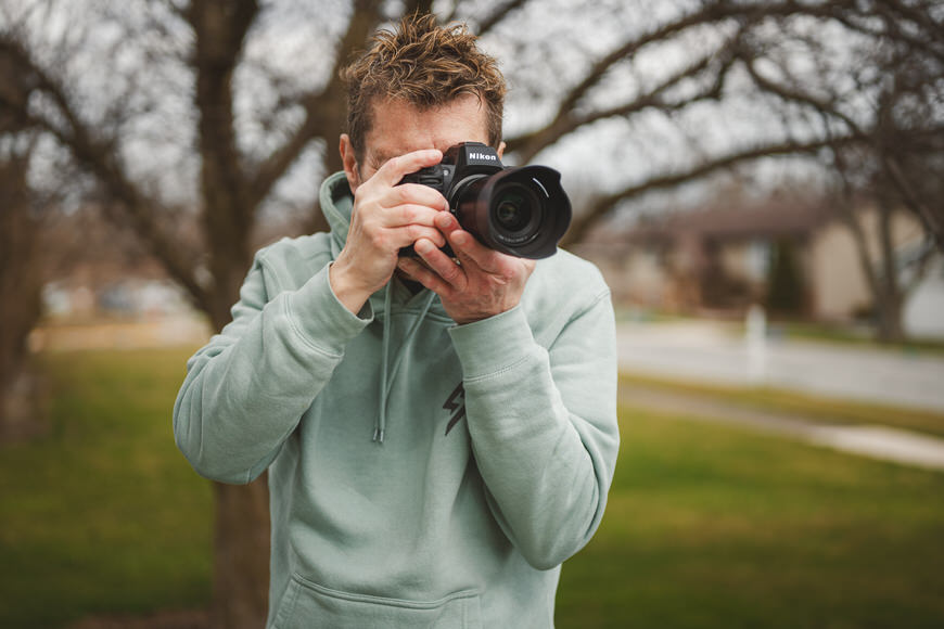 Man taking a photo with a dslr camera outdoors.