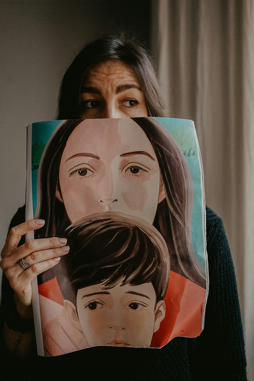 A woman holding up a picture of a woman and a child.