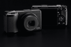 A ricoh gr compact digital camera displayed against a dark background.