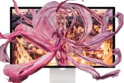 A dancer in a flowing pink costume appears to leap out of a computer monitor against a blurred cityscape background.