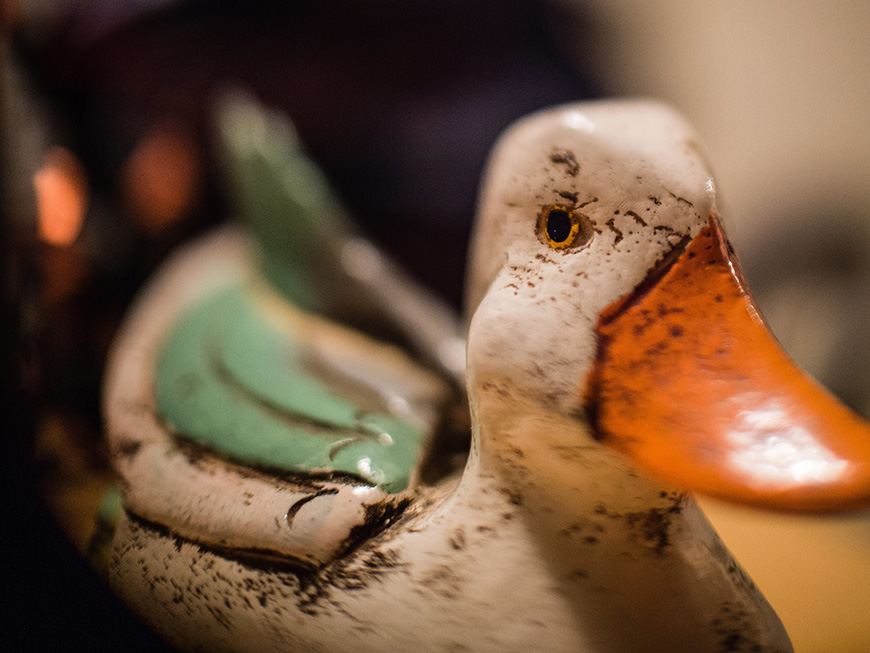 Close-up of a ceramic duck ornament with a focus on its head.
