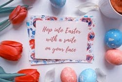 A festive easter greeting card surrounded by colorful eggs and tulips.