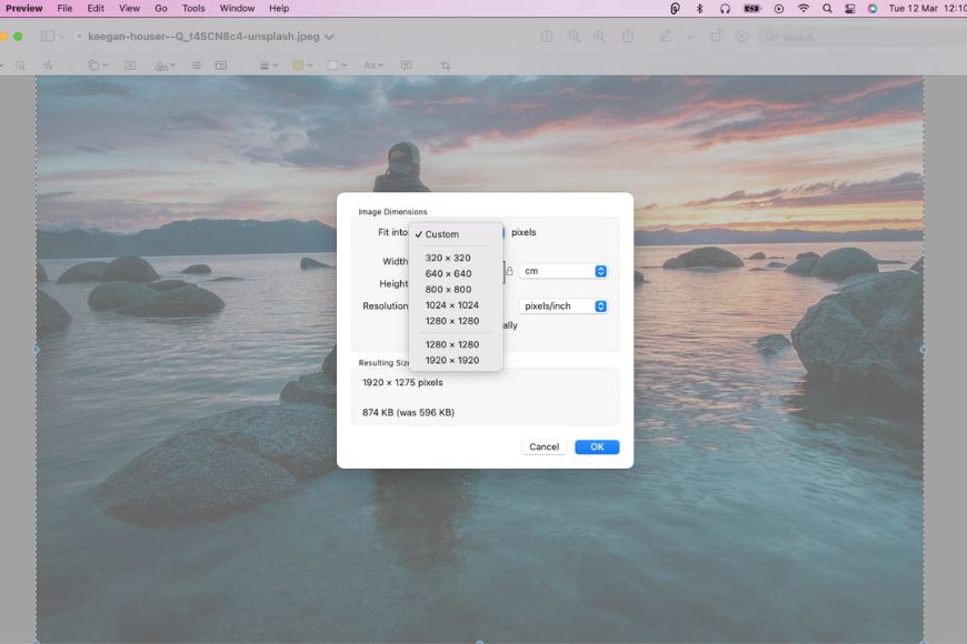 Image editing interface showing a resize dialog box over a serene background with water, rocks, and a person sitting facing a sunset or sunrise.
