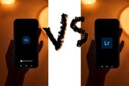 Two hands holding smartphones with adobe photoshop and lightroom logos on the screens, depicting a comparison or rivalry between the two photo editing applications.