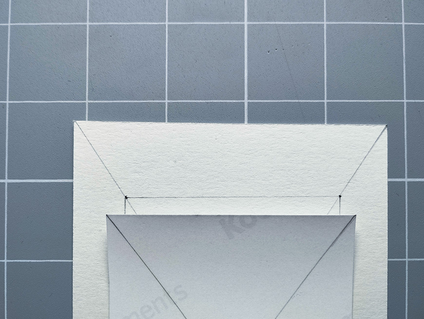 A blank white envelope on a gray tiled surface.