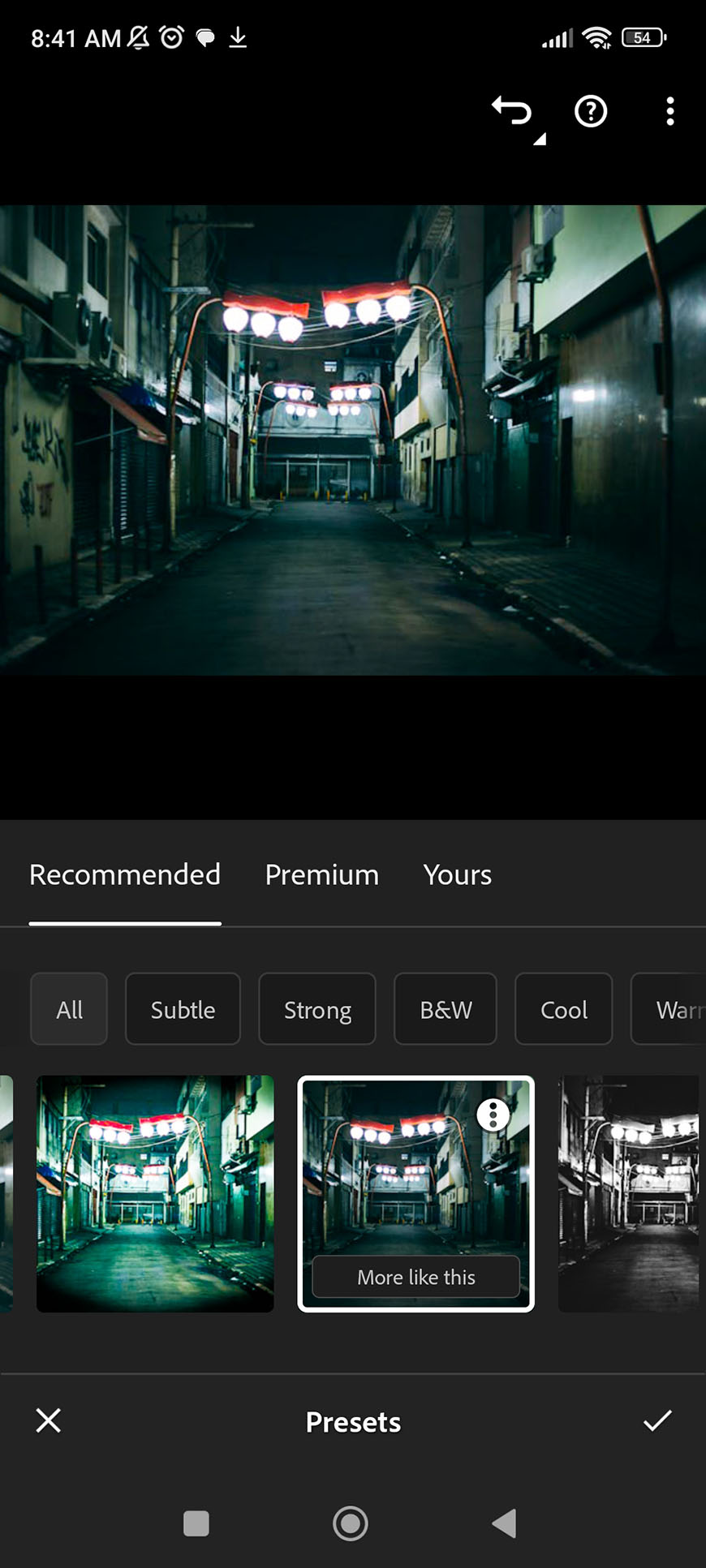 A mobile screen displaying a photo editing app with various filter options, using an image of an urban alleyway as the subject.